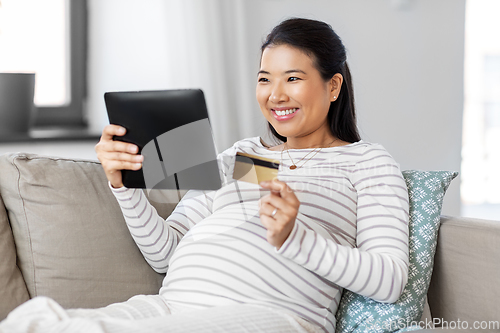 Image of pregnant woman with tablet pc and credit card