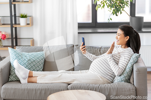 Image of happy pregnant woman having video call on phone