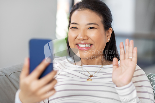 Image of asian woman with smartphone having video call