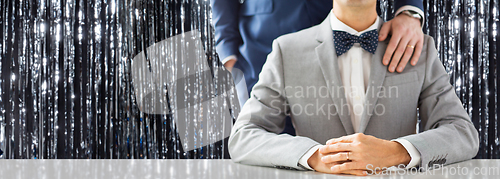 Image of close up of male gay couple with wedding rings on