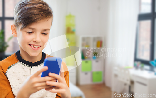 Image of boy with smartphone texting or playing at home