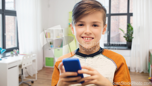 Image of boy with smartphone texting or playing at home