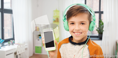 Image of happy boy with smartphone and headphones at home