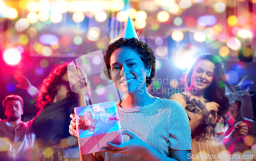 Image of african woman in party cap with gift box on black