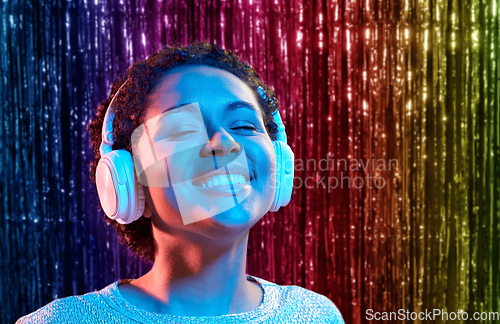 Image of african woman in headphones listening to music