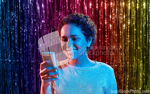 Image of african woman with smartphone at party