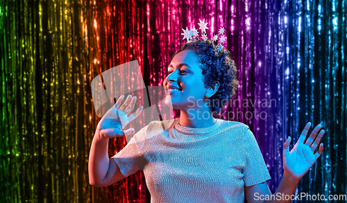 Image of african woman in party cap with blower over black