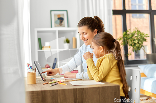 Image of mother and daughter with tablet pc drawing at home