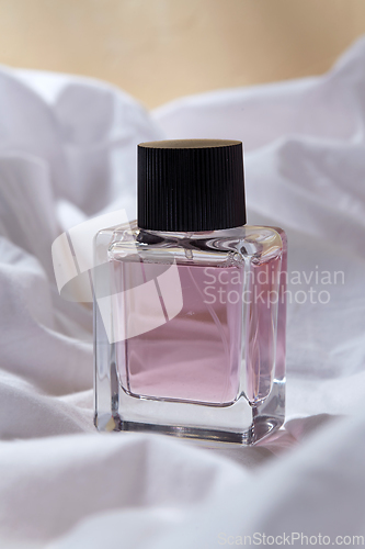 Image of bottle of perfume on white sheet