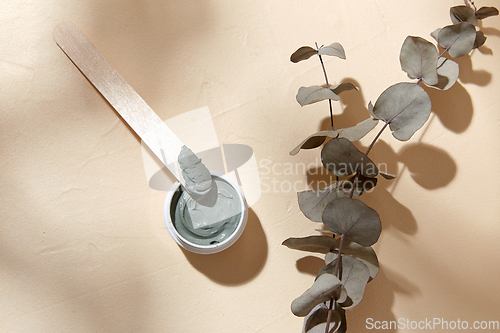 Image of cosmetic clay mask in jar with wooden spatula