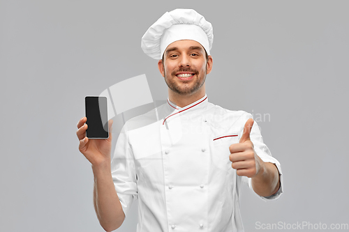 Image of happy chef with smartphone showing and thumbs up