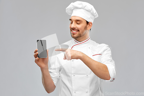 Image of happy smiling male chef showing smartphone