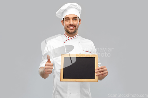 Image of happy male chef showing chalkboard and thumbs up