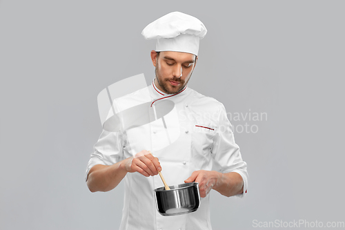 Image of male chef with saucepan cooking food