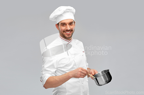 Image of happy smiling male chef with saucepan cooking food