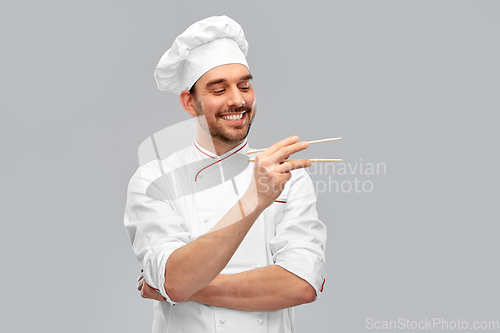 Image of happy smiling male chef with chopsticks