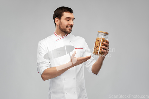 Image of happy smiling male chef with pasta in glass jar