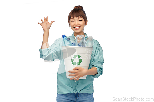 Image of smiling young asian woman sorting plastic waste