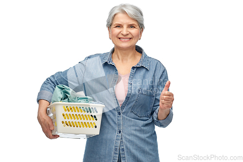 Image of smiling senior woman with laundry basket