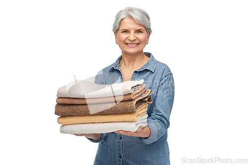 Image of smiling senior woman with clean bath towels