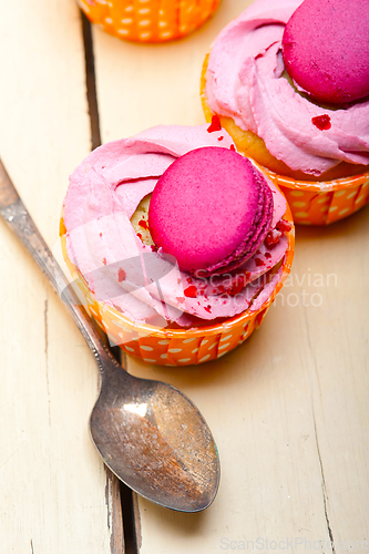 Image of pink berry cream cupcake with macaroon on top