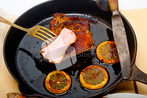 Image of pork chop seared on iron skillet