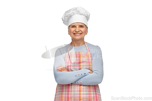 Image of smiling senior woman or chef in toque in apron