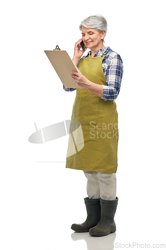 Image of old female gardener with clipboard calls on phone