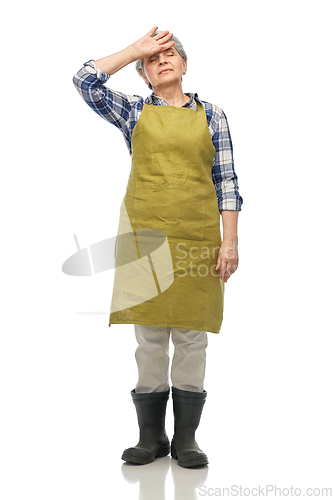 Image of tired senior woman in garden apron