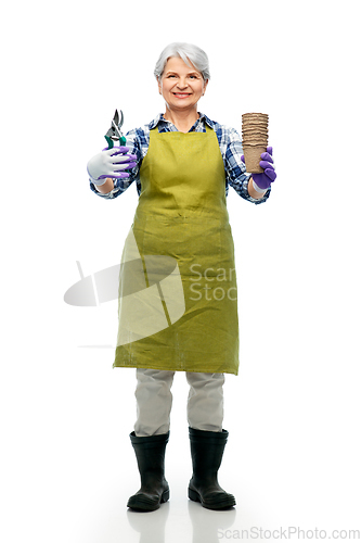 Image of old woman in apron with pruner and flower pots