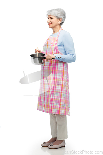 Image of senior woman in apron with pot cooking food