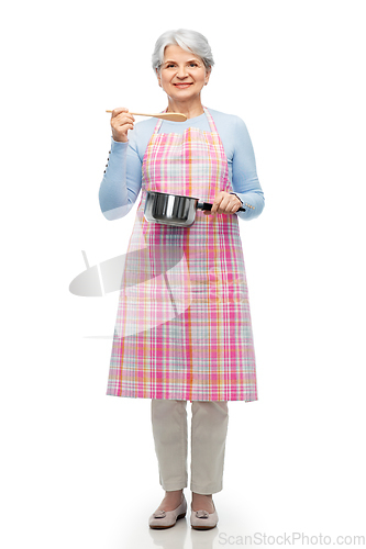 Image of senior woman in apron with pot cooking food