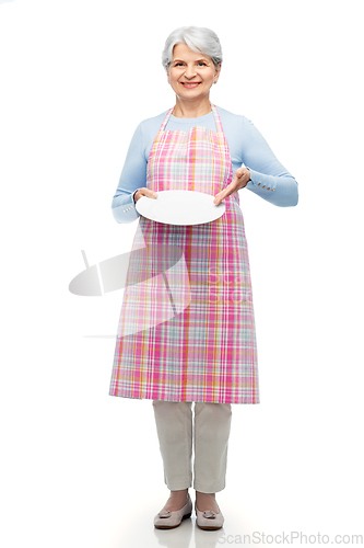 Image of smiling senior woman in apron with empty plate