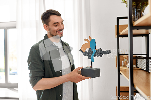 Image of man decorating home with art in frame