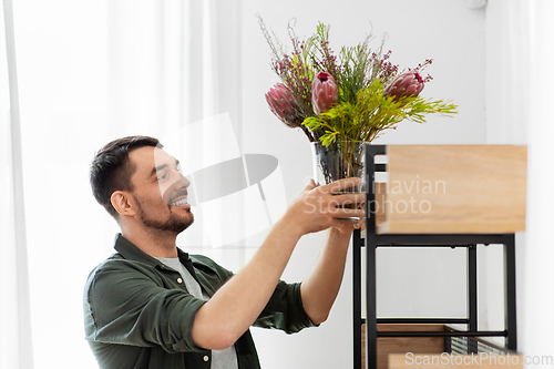 Image of man decorating home with flower or houseplant