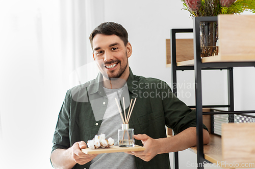 Image of man placing aroma reed diffuser to shelf home