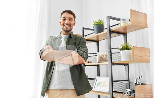 Image of happy smiling man with crossed arms at home