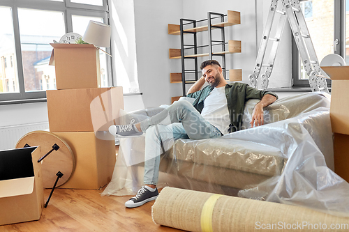 Image of happy man with boxes moving to new home