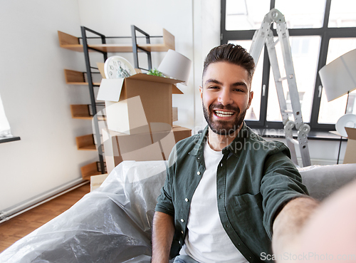 Image of man having video call and moving into new home