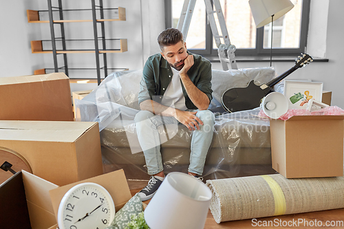 Image of sad man with boxes moving to new home