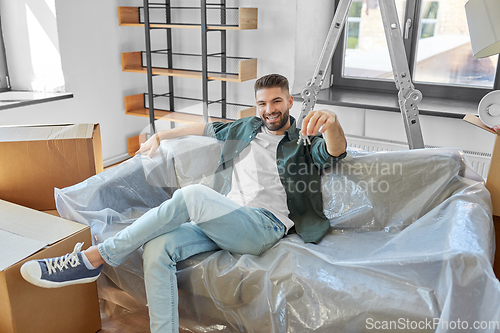 Image of man with house keys and boxes moving to new home