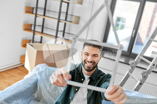 Image of happy man with boxes moving to new home