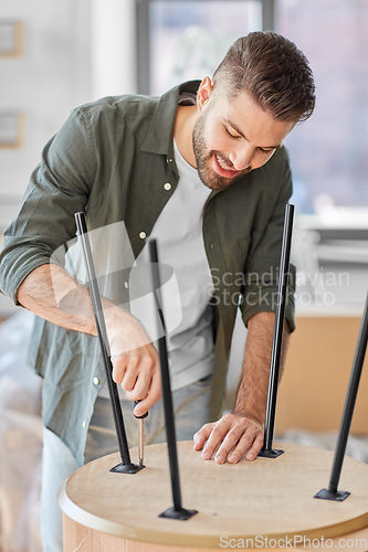 Image of happy man assembling coffee table at new home