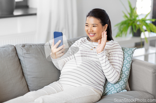 Image of happy pregnant woman having video call on phone