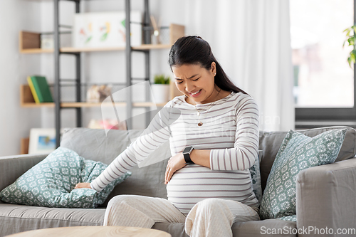 Image of pregnant woman having labor contractions at home