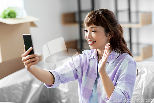 Image of woman having video call and moving into new home