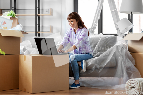 Image of woman with laptop moving into new home