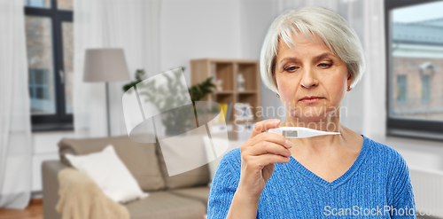 Image of sick senior woman with thermometer