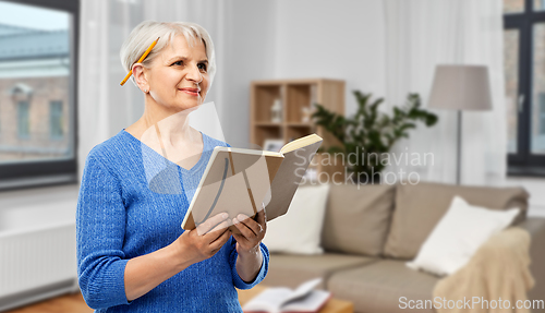 Image of senior woman with pencil and diary or notebook