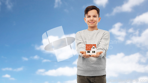 Image of smiling boy holding house model